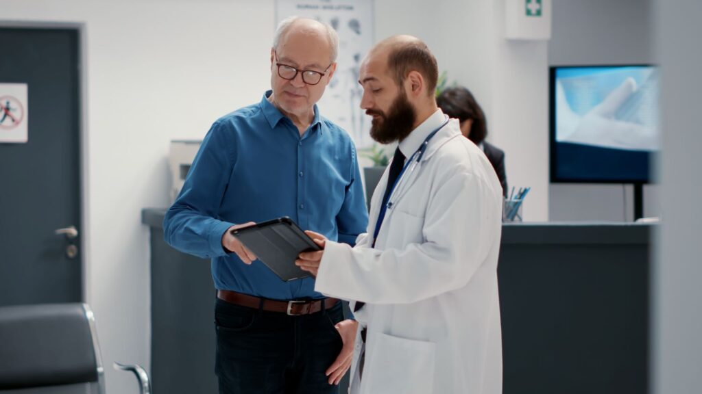 Médico e paciente conversam sobre tratamento da HPB em ambiente hospitalar