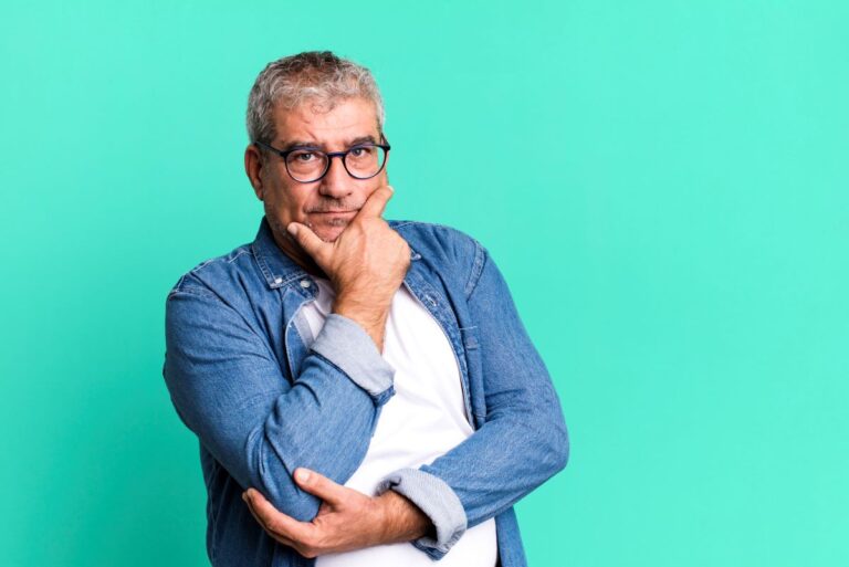 Homem com pose pensativa com mão no queixo reflete sobre a próstata aumentada e como diminuir