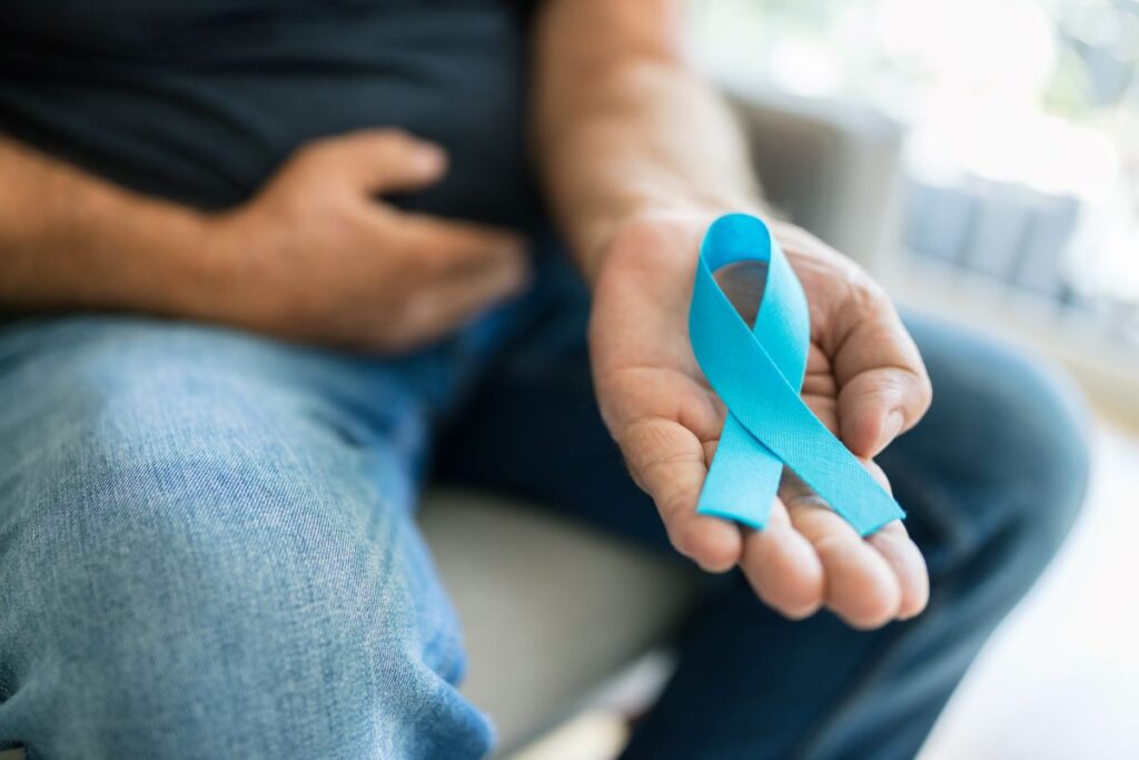 Homem segura laço azul, que simbolia o câncer de próstata. Sintomas podem ser sutis