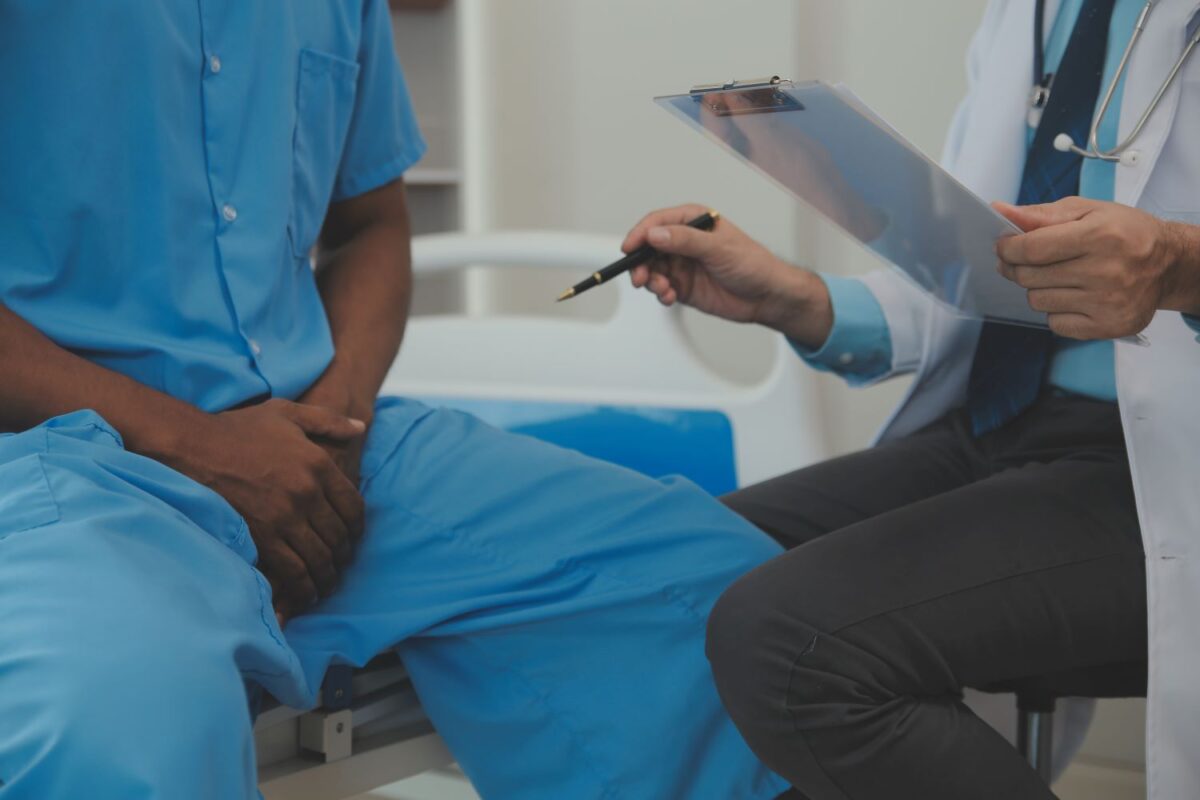 Paciente em idade ideal para fazer exame de próstata, sentado conversa com médico ambiente hospitalar