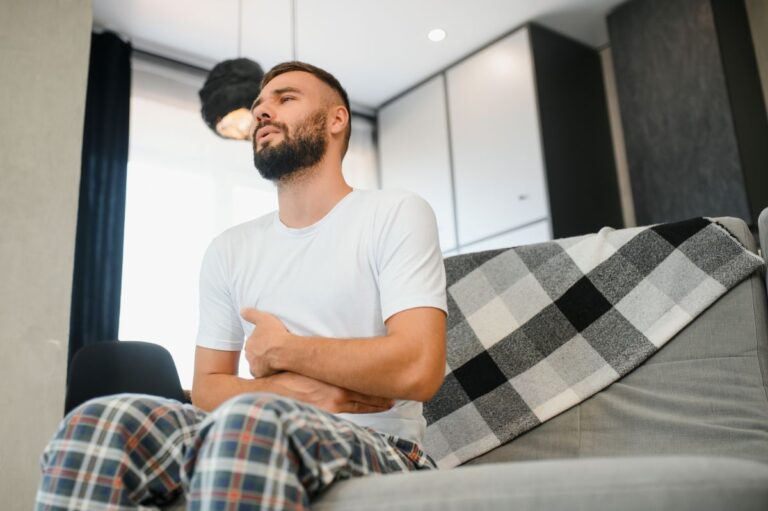 Homem jovem faz expressão de dor devido à próstata inflamada