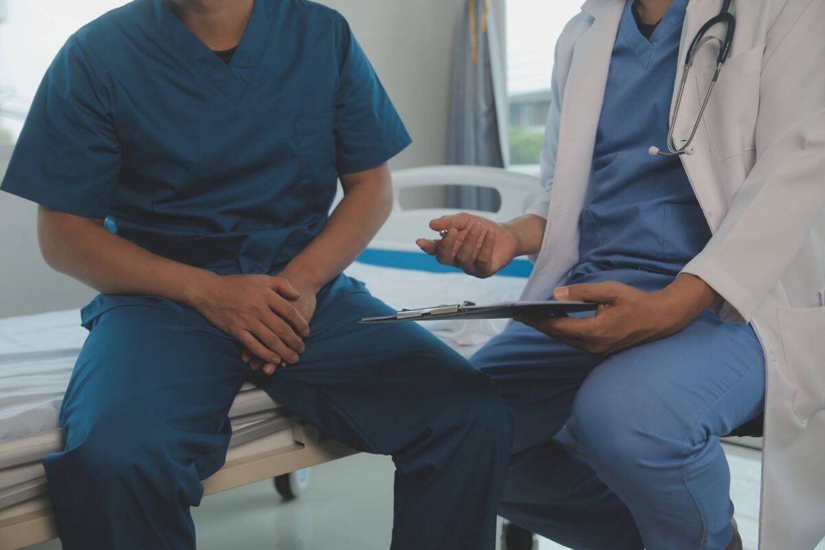 Médico urologista orientando paciente sobre resultado de biópsia de próstata Gleason 9 em consultório, ilustrando diagnóstico e opções de tratamento para câncer de próstata grau 9.
