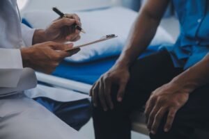 Médico registra informações durante consulta com paciente para discutir diagnóstico e tratamento, incluindo casos clínicos HoLEP e Rezum.